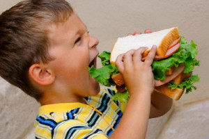 Boy Eating Huge Sandwich --- Image by © Dean Muz/Design Pics/Corbis